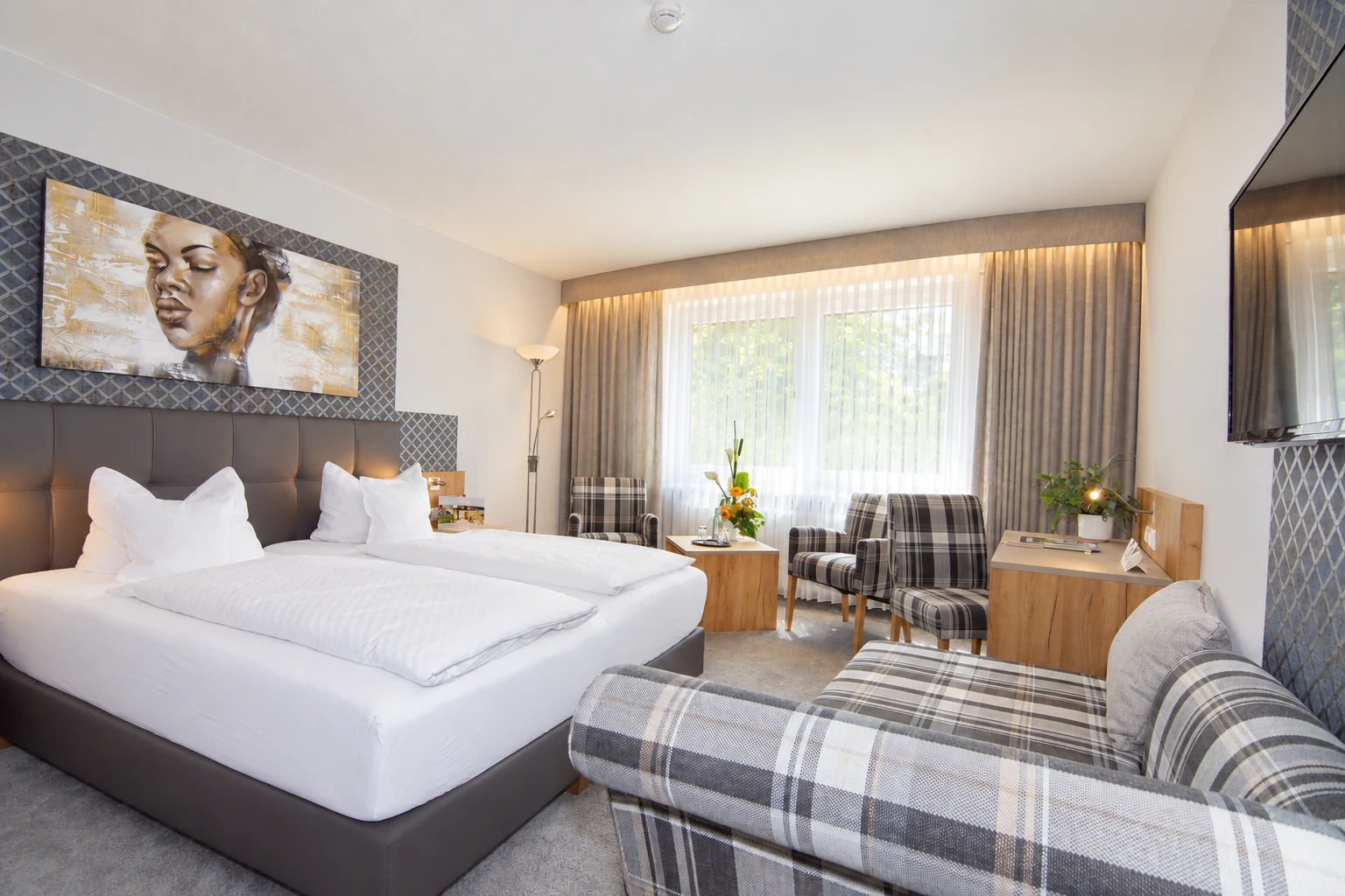 Doppelzimmer im Hotel Riemann mit weißer Bettwäsche und Sitzgruppe