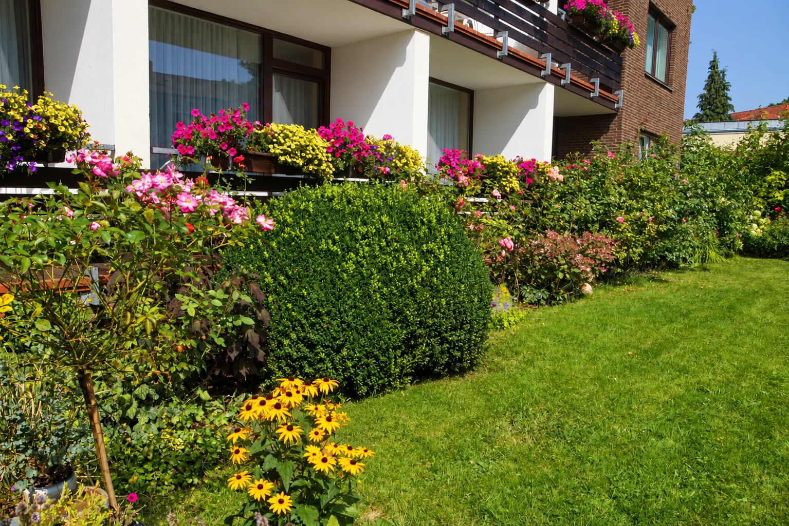 Blühender Hotelgarten vor den Balkonen